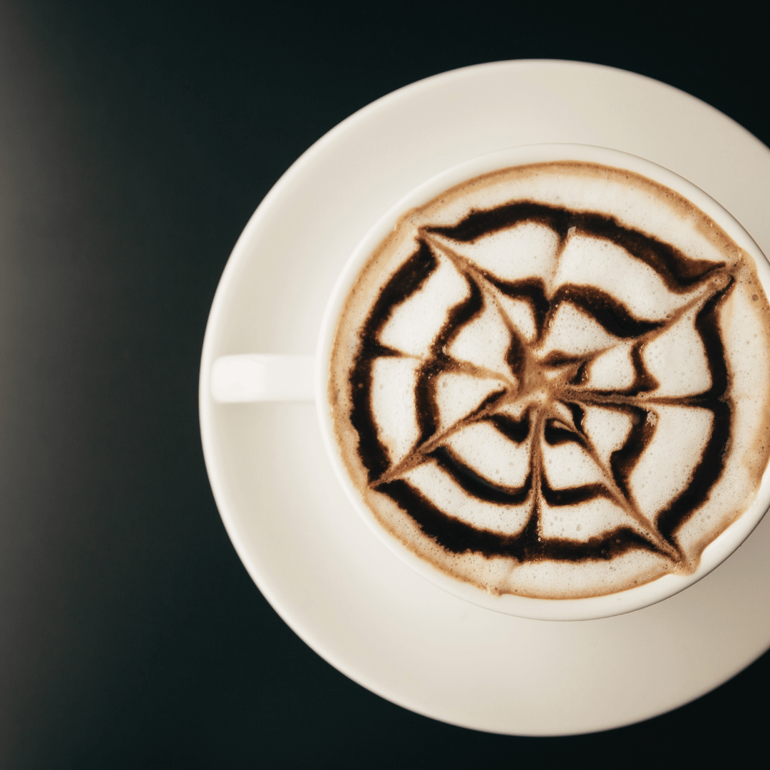 Bæger med hjemmelavet Caffe Mocha, toppet med mælkeskum og drysset med kakaopulver – en lækker kombination af chokolade og espresso for kaffeelskere.