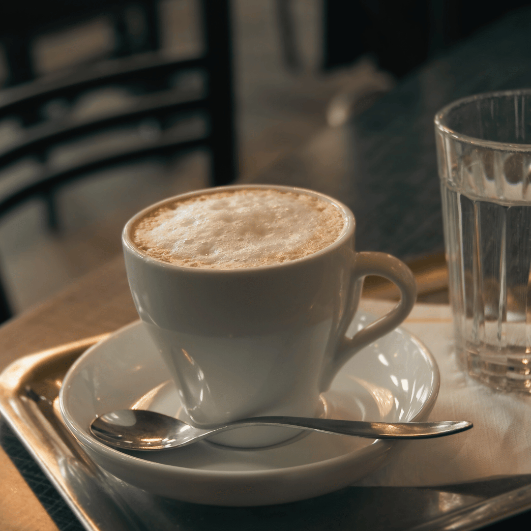 En dampende kop Wiener Melange med et lag mælkeskum serveret i en elegant kaffekop, perfekt til en luksuriøs kaffeoplevelse.