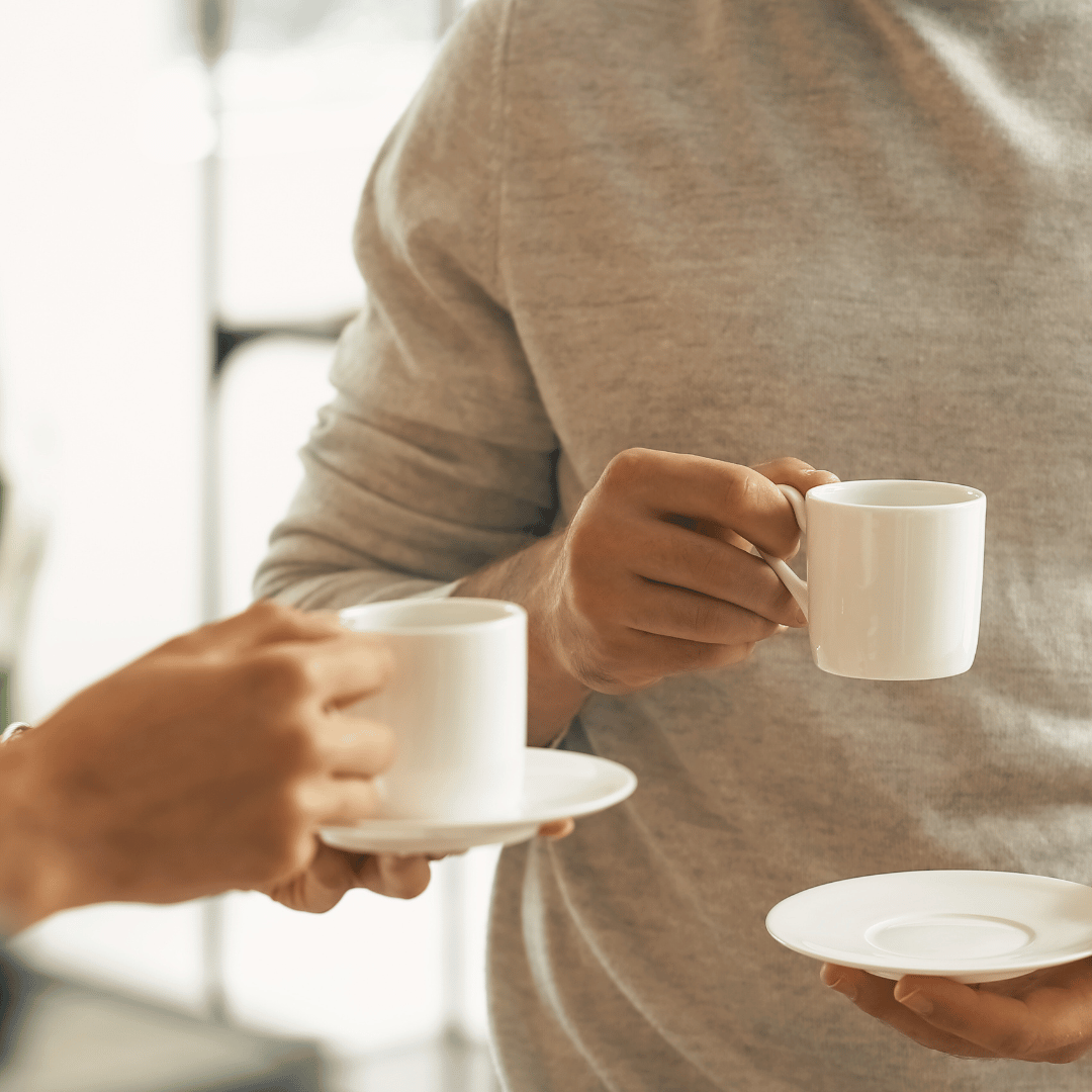 En dampende kop kaffe på et nordisk træbord med sneklædte bjerge i baggrunden – en hyldest til de nordiske landes kaffeelskende kultur.
