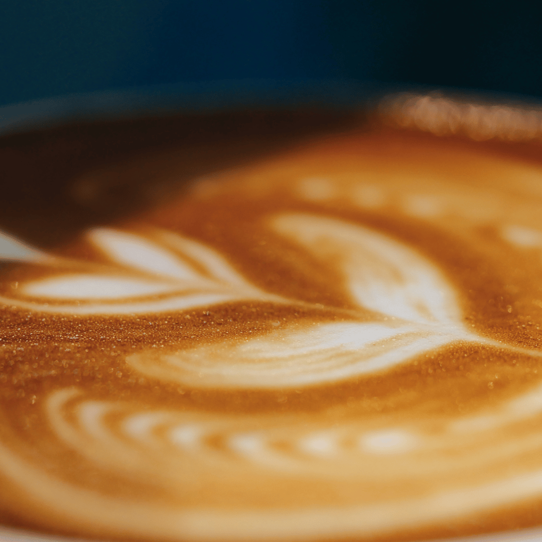 En kop dampende kaffe placeret på et bord med bønner og et kaffefilter, der symboliserer de mange sundhedsmæssige og smagsmæssige fordele ved at drikke friskristet kaffe.