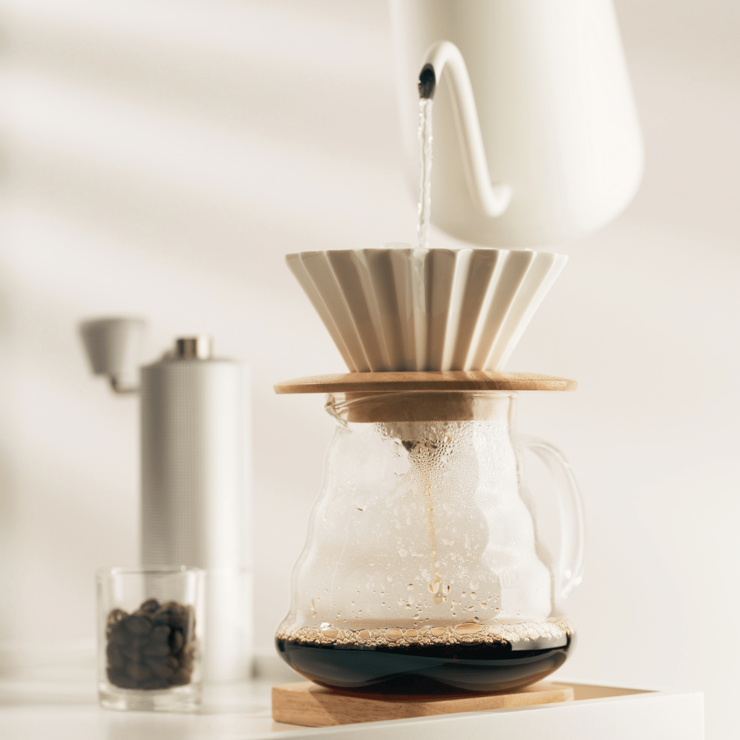 Slow brew kaffe brygget i en Chemex med dampende kaffe og aromatiske noter, der fremhæver kaffeens rige smagsnuancer.