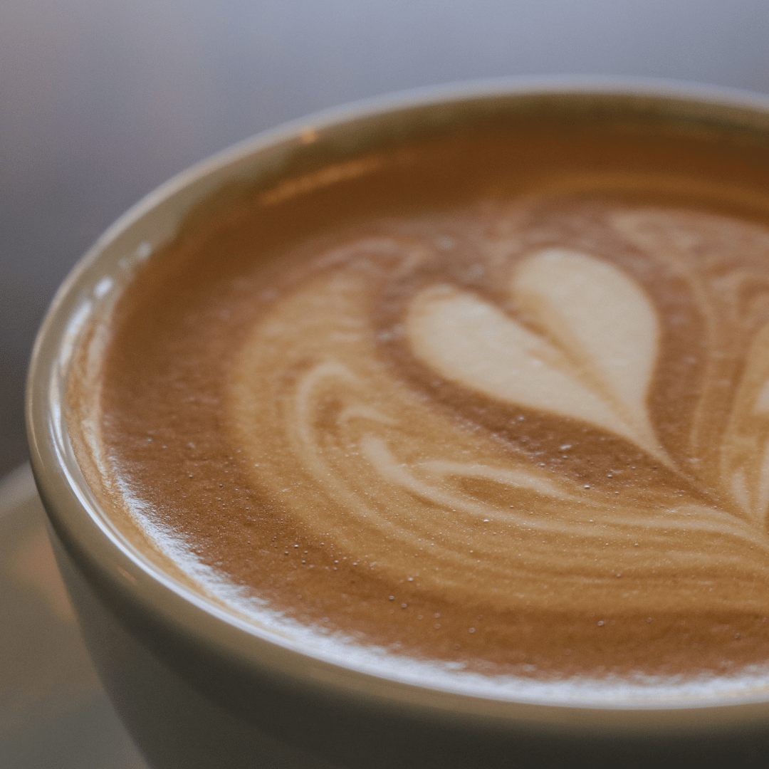 En kop Café con Leche lavet med stærk kaffe og varm mælk, serveret i en hvid kop.