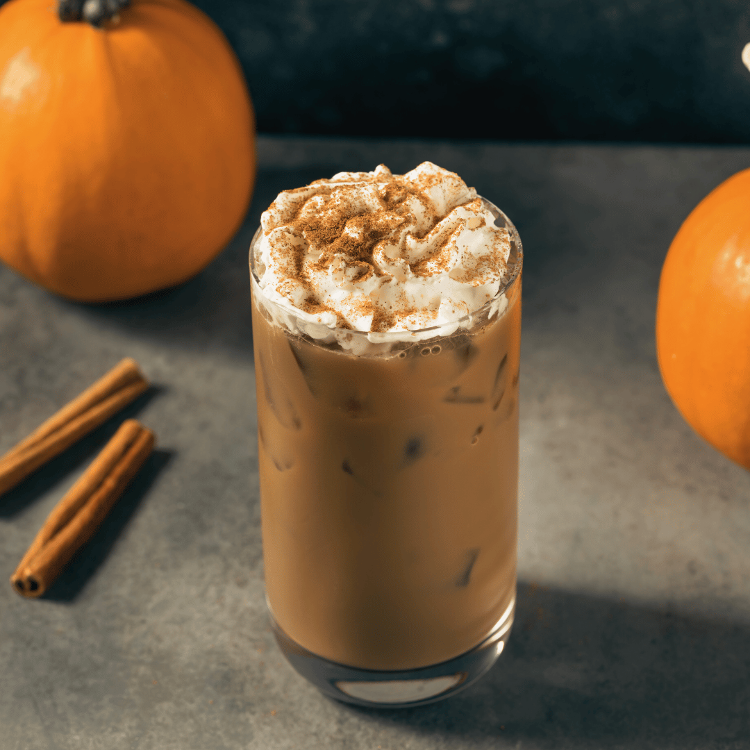 En lækker Iced Pumpkin Spiced Latte lavet med mellemristet kaffe fra Rwanda, toppet med flødeskum og drysset med græskarkrydderi. Perfekt efterårsdrik med frugtige undertoner og varme krydderier.