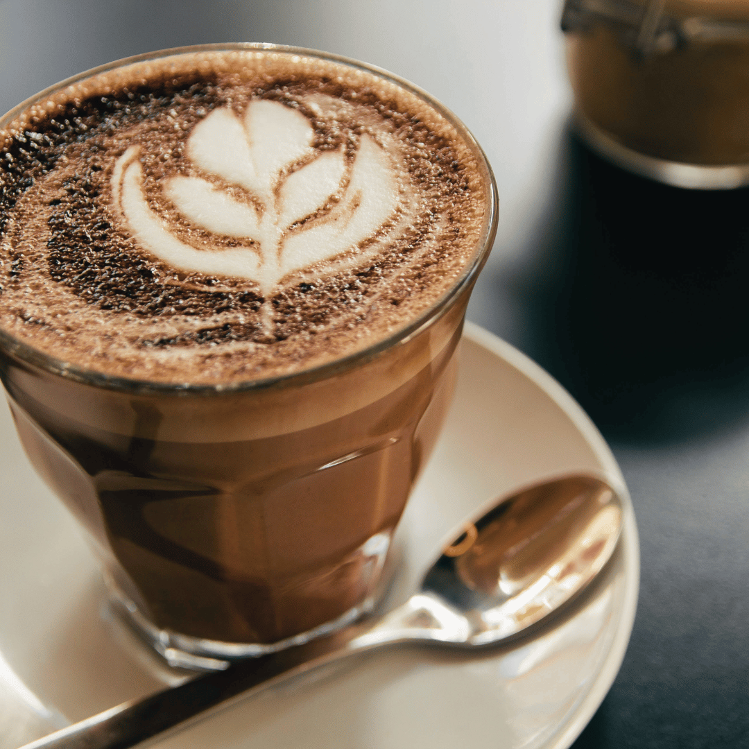 Et glas Bicerin med perfekt lagdeling af espresso, rig varm chokolade og cremet flødeskum, serveret i et elegant glas og pyntet med revet chokolade – en italiensk kaffespecialitet fra Torino, der kombinerer smag og historie.