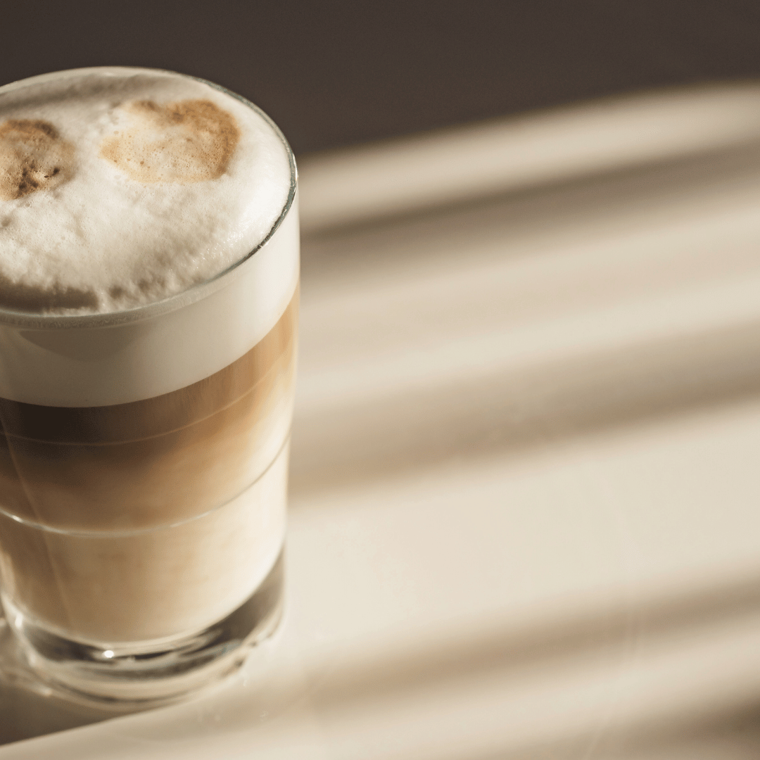 Latte macchiato opskrift: En elegant latte macchiato lavet med mellemristede bønner fra Colombia, dampet mælk og et lag skum.