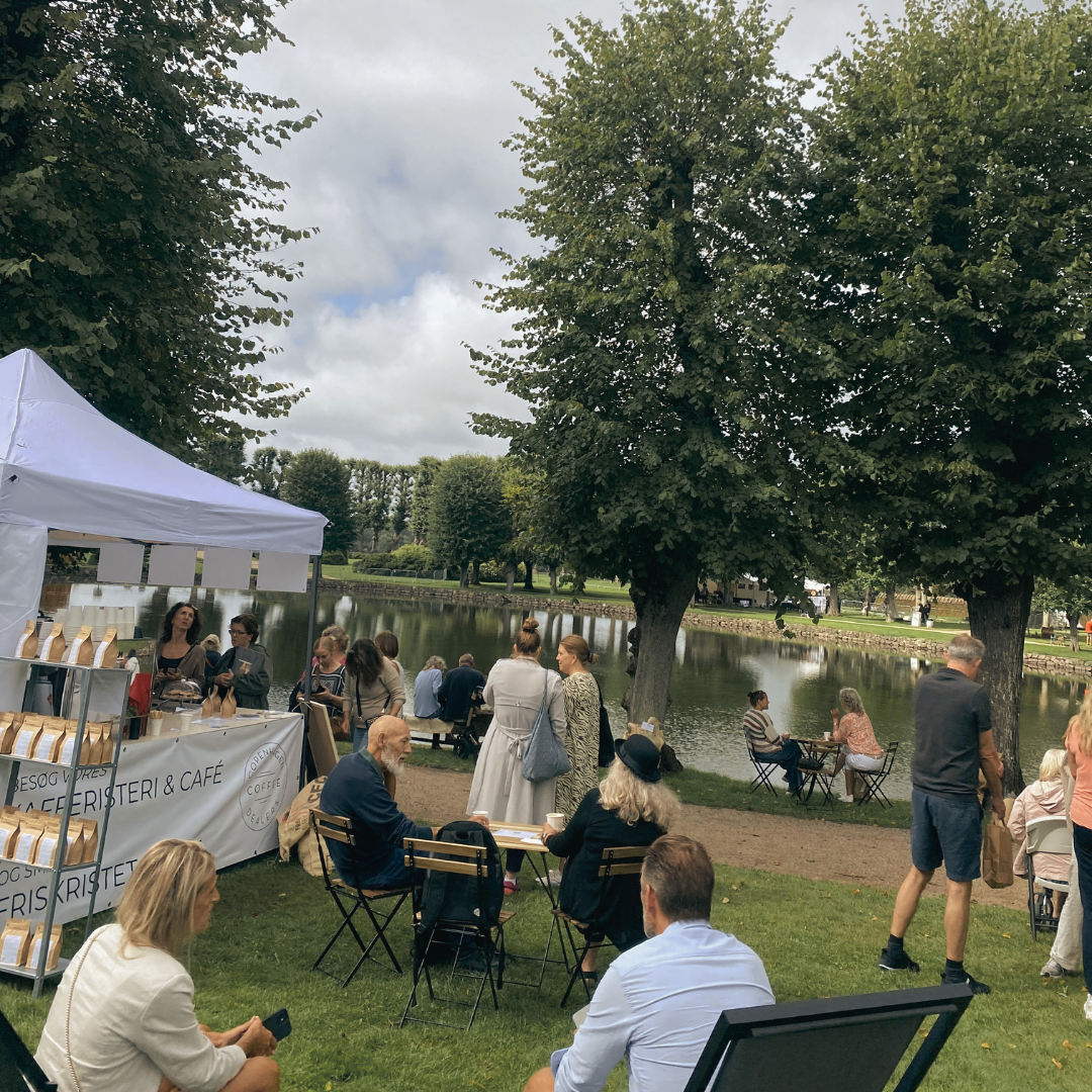 Gæster nyder friskbrygget kaffe fra en mobil kaffebar ved et stort event.