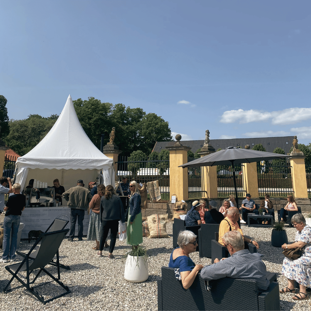Smilende gæster modtager friskbrygget kaffe fra en eksklusiv kaffebar til events.